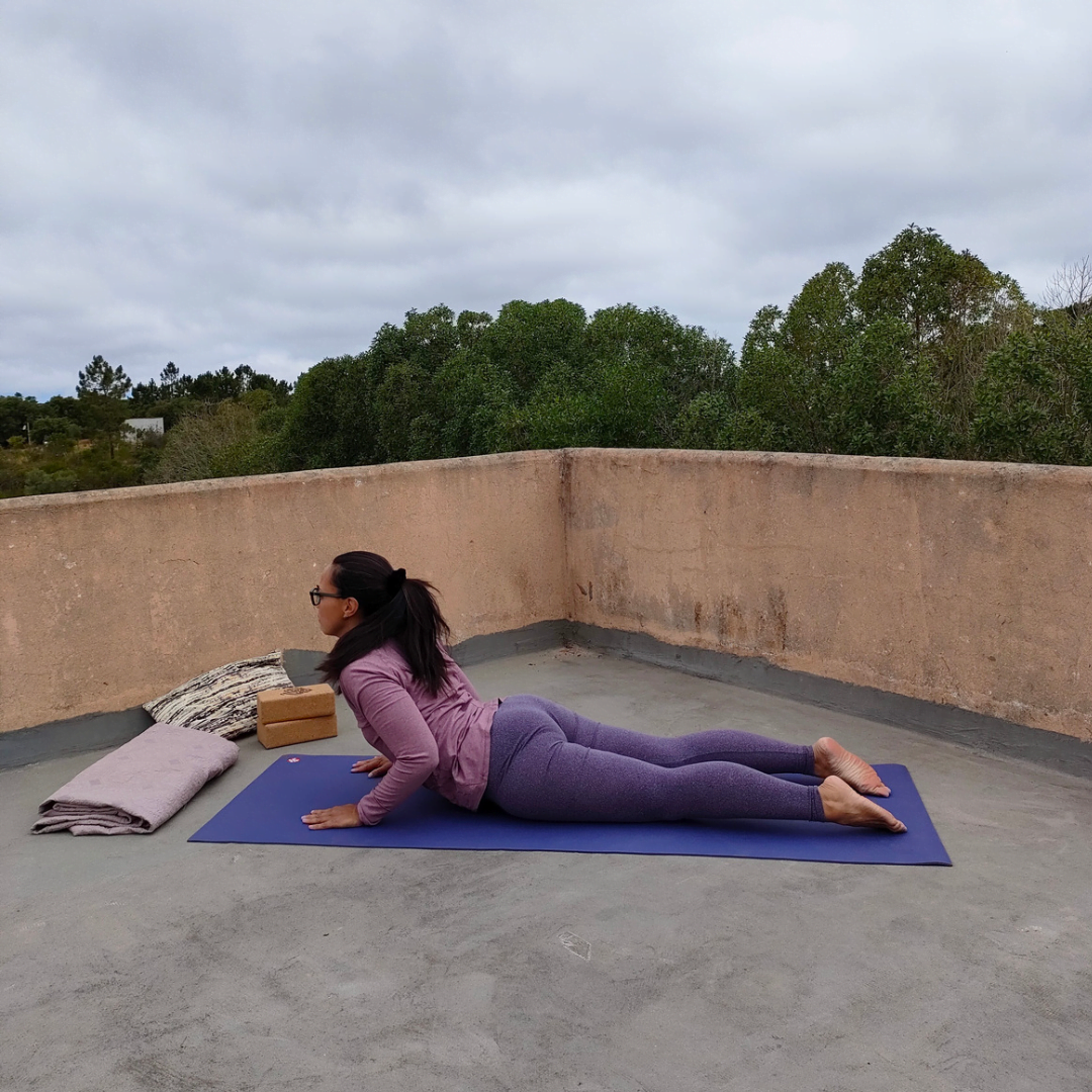 Pamela van Yogarve buiten op een yogamatje in de cobra houding